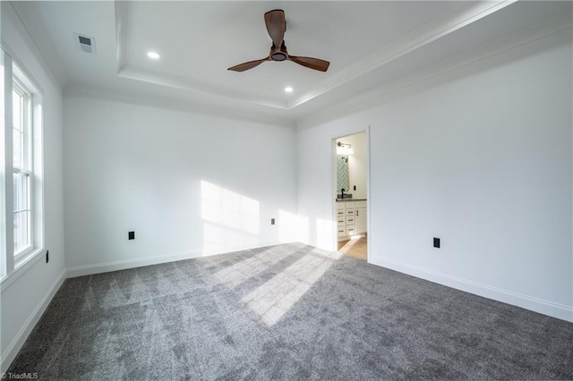 unfurnished room featuring a tray ceiling, visible vents, carpet, and recessed lighting