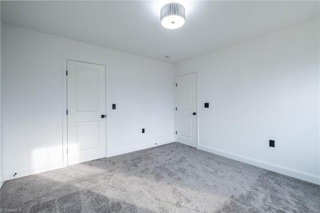 carpeted empty room featuring baseboards