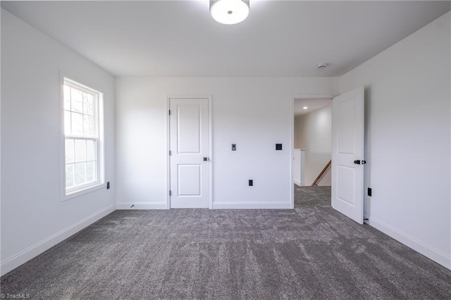 unfurnished bedroom featuring carpet and baseboards