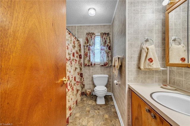 bathroom featuring tile walls, vanity, ornamental molding, a textured ceiling, and toilet