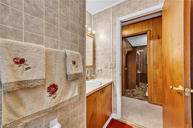 bathroom with vanity and tile walls