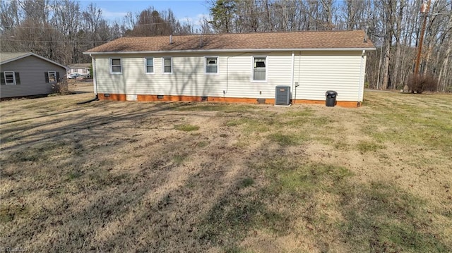 rear view of property with cooling unit and a yard