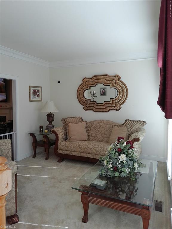 living room featuring carpet floors and ornamental molding