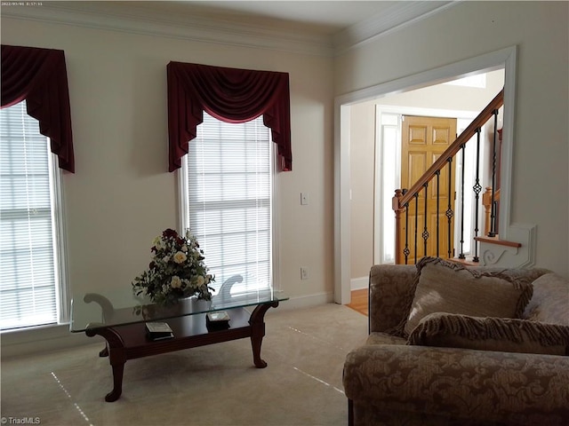 living room featuring plenty of natural light, ornamental molding, and light carpet