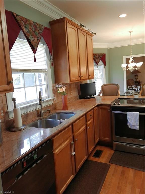 kitchen with pendant lighting, electric stove, sink, light wood-type flooring, and black dishwasher