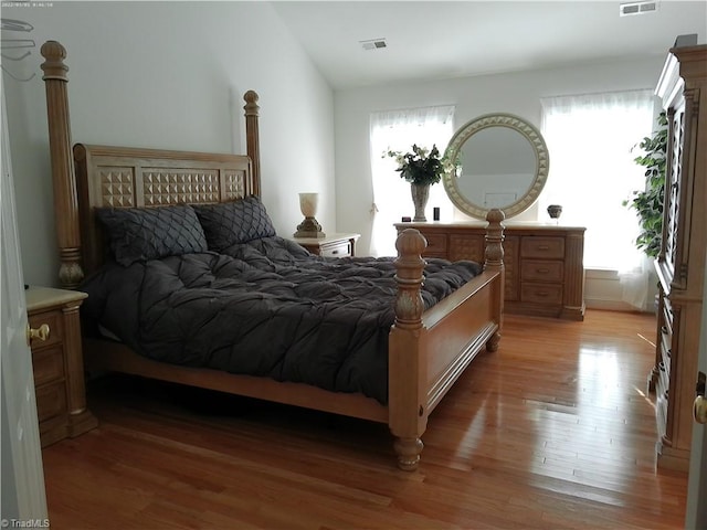 bedroom with hardwood / wood-style floors and vaulted ceiling