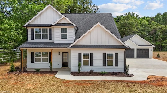 1329 Union Cross Rd, Kernersville, NC 27284 - view of front facade with board and batten siding, covered porch, a shingled roof, fence, and a garage