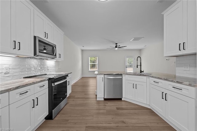 1329 Union Cross Rd, Kernersville, NC 27284 - kitchen featuring stainless steel appliances, a sink, light wood-style floors, ceiling fan, and white cabinetry