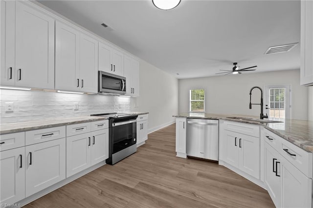 1329 Union Cross Rd, Kernersville, NC 27284 - kitchen featuring stainless steel appliances, a sink, light wood-style flooring, backsplash, and ceiling fan
