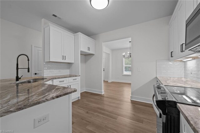 1329 Union Cross Rd, Kernersville, NC 27284 - kitchen with a sink, appliances with stainless steel finishes, white cabinetry, stone countertops, and wood finished floors