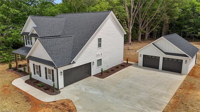 1329 Union Cross Rd, Kernersville, NC 27284 - view of home's exterior featuring roof with shingles, concrete driveway, view of wooded area, and an outbuilding