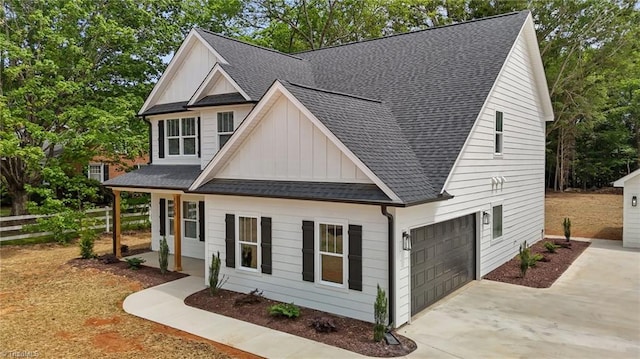 1329 Union Cross Rd, Kernersville, NC 27284 - view of front facade featuring board and batten siding, roof with shingles, driveway, fence, and a garage
