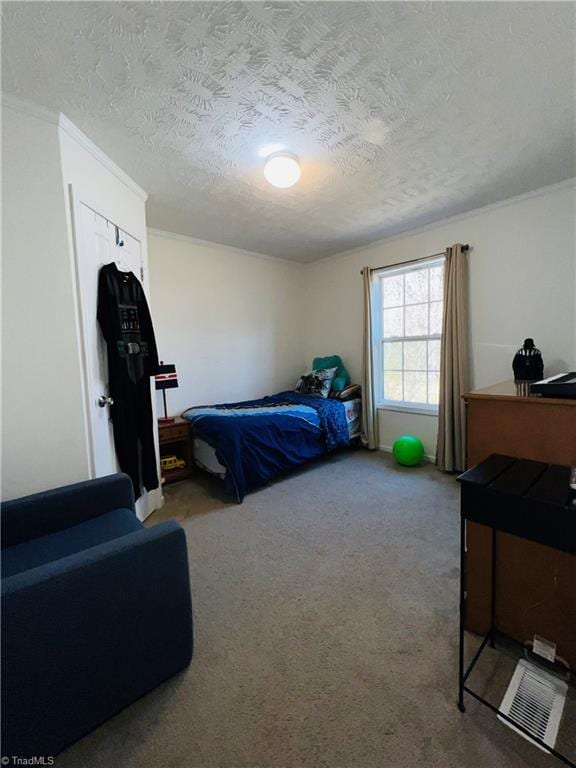 bedroom featuring crown molding, carpet floors, and a textured ceiling