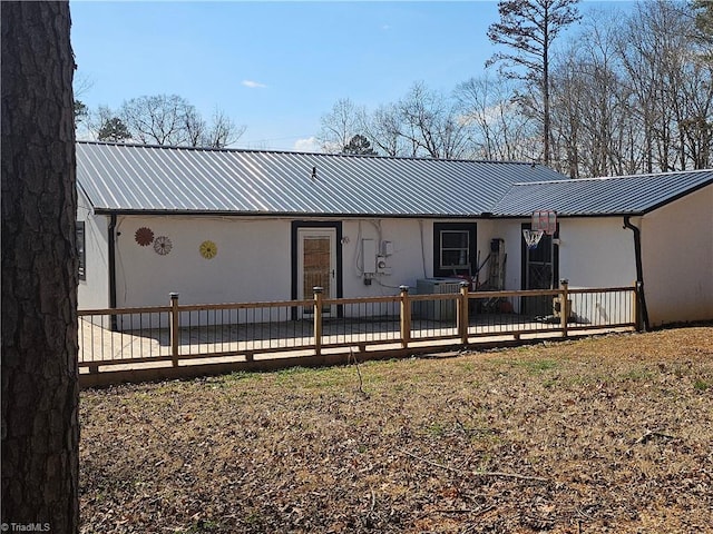 view of front of home featuring a deck, metal roof, and stucco siding