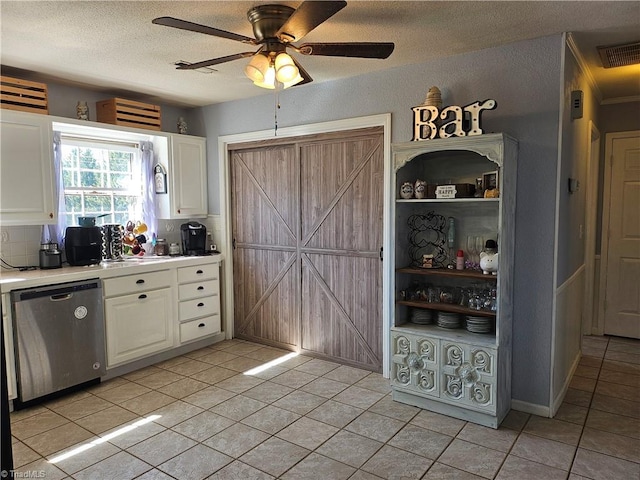 kitchen with a barn door, visible vents, white cabinetry, light countertops, and dishwasher