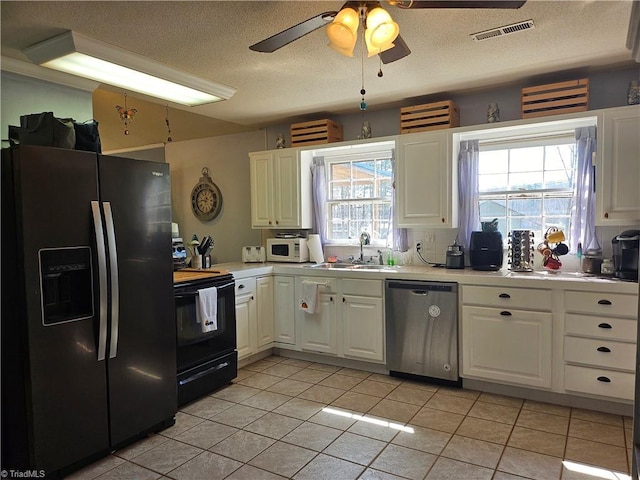 kitchen featuring visible vents, black electric range oven, fridge with ice dispenser, stainless steel dishwasher, and a sink