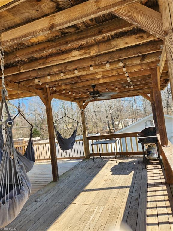 wooden deck featuring area for grilling and a ceiling fan