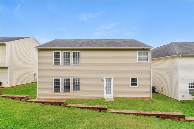 rear view of house with a lawn and cooling unit