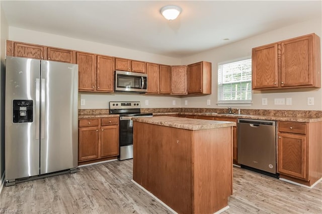 kitchen featuring a center island, light wood-type flooring, sink, and appliances with stainless steel finishes