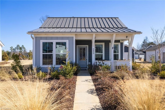 bungalow-style house with a standing seam roof and metal roof