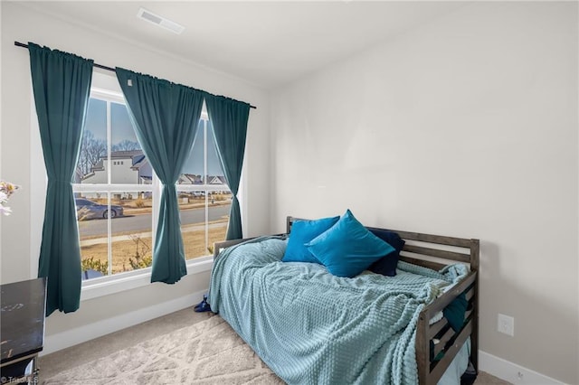 carpeted bedroom featuring visible vents and baseboards