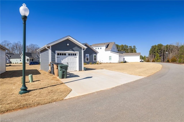 view of front of house with a garage, a residential view, and concrete driveway