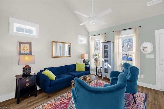 living room featuring wood finished floors, a ceiling fan, visible vents, vaulted ceiling, and baseboards