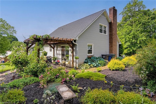 view of property exterior with a pergola, a chimney, a patio, and roof with shingles