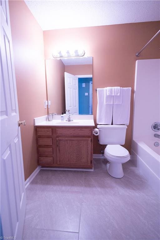 full bath with shower / washtub combination, tile patterned floors, vanity, toilet, and baseboards