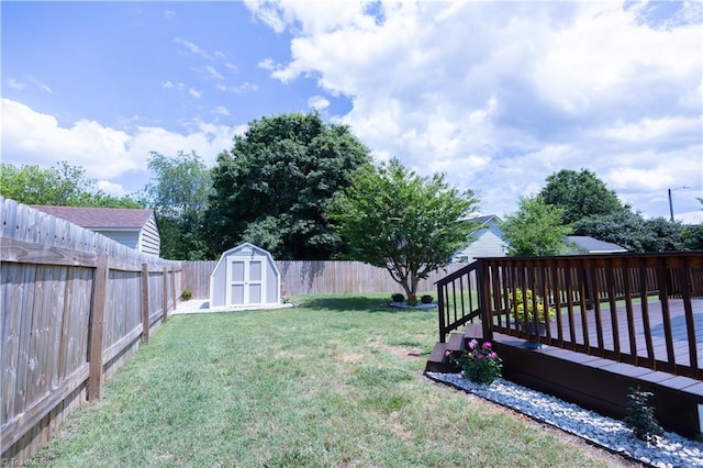 view of yard featuring a storage shed, an outdoor structure, and a wooden deck