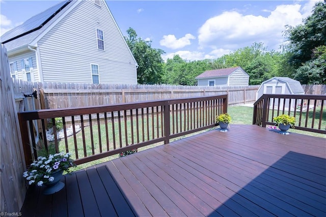 wooden deck featuring a storage unit and an outdoor structure