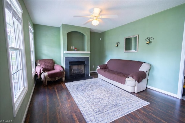 living room with a fireplace with flush hearth, plenty of natural light, baseboards, and wood finished floors