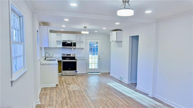 kitchen featuring pendant lighting, white cabinets, ornamental molding, stainless steel appliances, and light hardwood / wood-style flooring