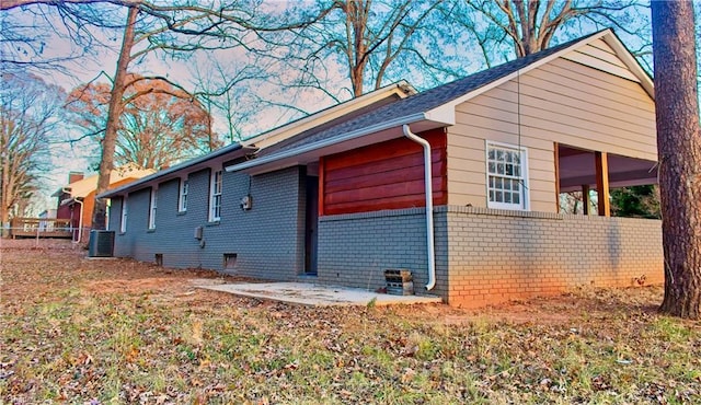 view of side of property with a patio and central air condition unit