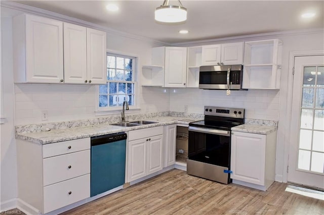 kitchen with sink, white cabinetry, stainless steel appliances, ornamental molding, and light hardwood / wood-style floors