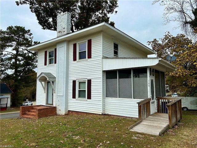 exterior space featuring a yard and a sunroom