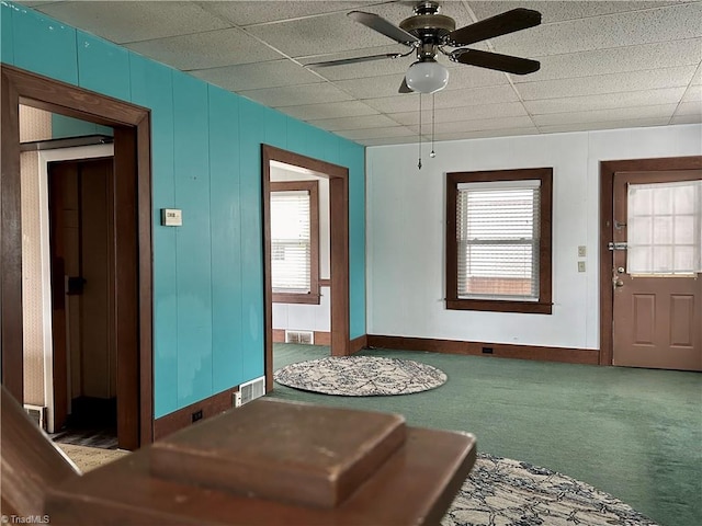 carpeted entrance foyer featuring a paneled ceiling, plenty of natural light, and ceiling fan