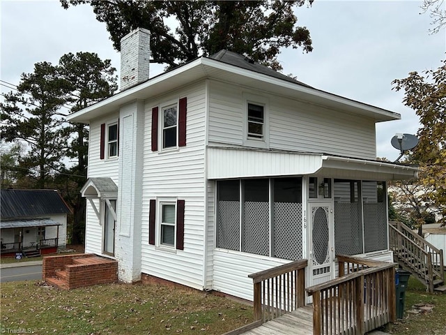 rear view of house featuring a sunroom