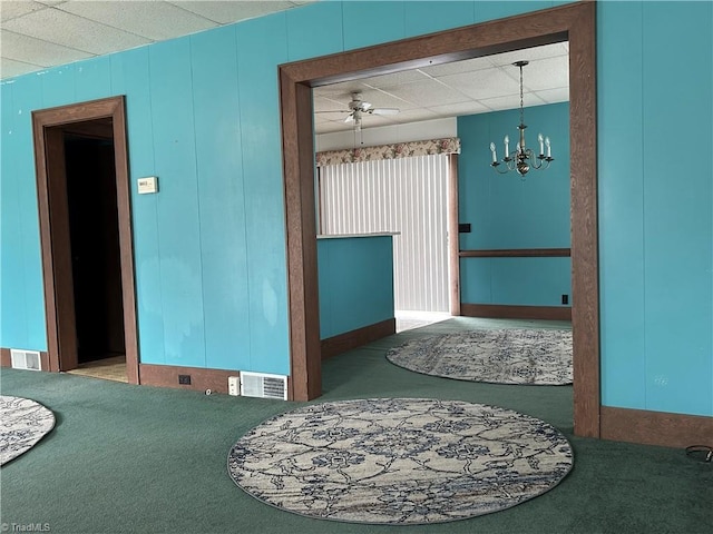 spare room with carpet flooring and ceiling fan with notable chandelier