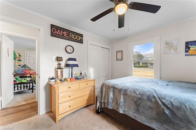 bedroom with ceiling fan, light hardwood / wood-style floors, crown molding, and a closet