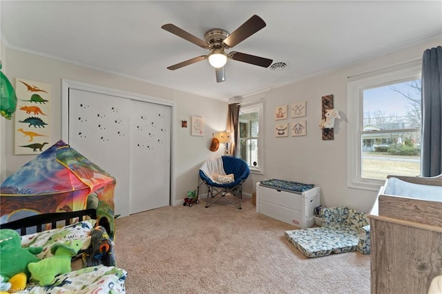 bedroom featuring a closet, ceiling fan, crown molding, and carpet