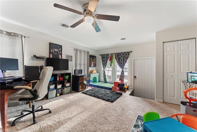 carpeted office space with ceiling fan