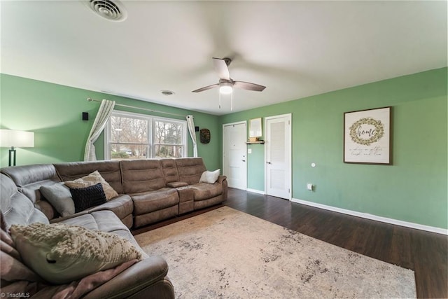 living area with ceiling fan, visible vents, baseboards, and dark wood-style floors