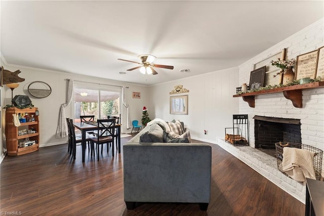 living room featuring a fireplace, dark hardwood / wood-style flooring, ceiling fan, and ornamental molding