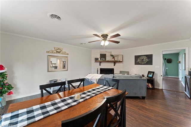 dining area with a fireplace, dark hardwood / wood-style flooring, and crown molding