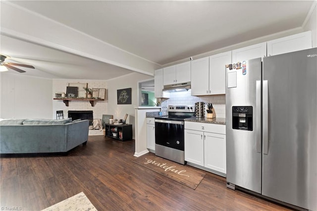 kitchen with white cabinets, stainless steel appliances, a brick fireplace, and dark wood-type flooring