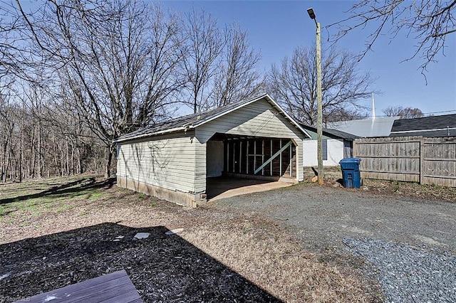 view of outdoor structure with fence and an outbuilding