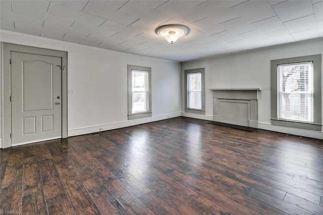 unfurnished living room with ornamental molding, a fireplace, baseboards, and wood finished floors