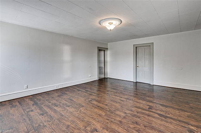 spare room with crown molding, baseboards, and wood finished floors