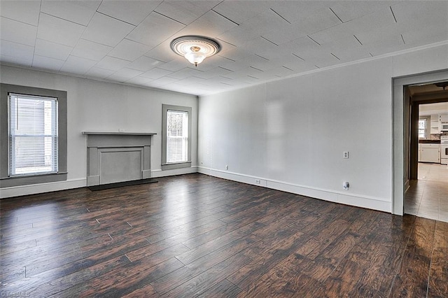 unfurnished living room featuring a fireplace, baseboards, and wood finished floors